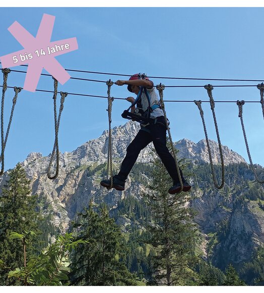 Kind auf Seilbrücke vor Bergkulisse, Text "5 bis 14 Jahre"