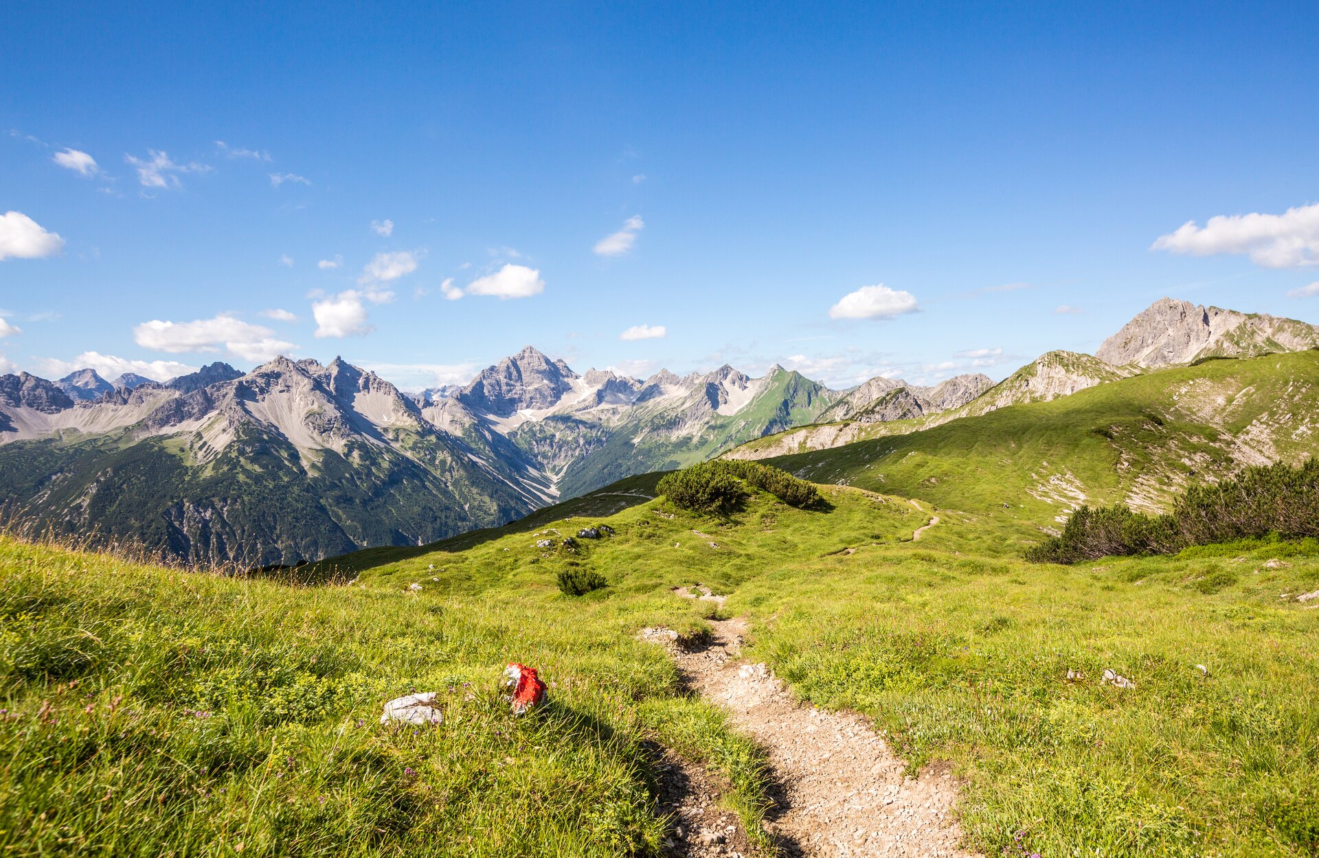 Berglandschaft mit Wanderweg unter blauem Himmel