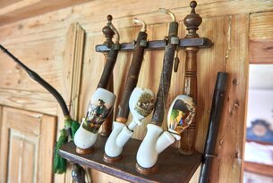 Alte Pfeifen mit Porzellanköpfen an einer Holzhalterung