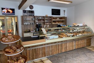 Innenansicht einer Bäckerei mit Theke, Brot, Gebäck und Regalen