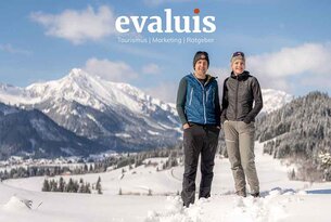 Zwei Personen im Schnee vor Bergpanorama, Logo evaluis Tourismus Marketing Ratgeber