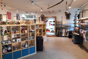 Innenansicht eines Bekleidungsgeschäfts mit Regalen und Kleiderständern