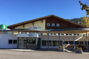 Gebäude mit Aufschrift "Tannheimer Tal" vor blauem Himmel