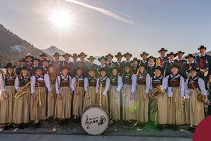 Trachtenkapelle mit Musikinstrumenten vor Bergkulisse