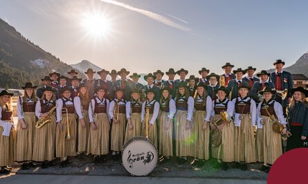 Trachtenkapelle mit Musikinstrumenten vor Bergkulisse