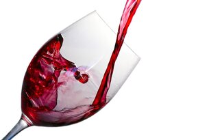 Rotwein wird in ein Weinglas gegossen
