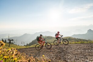 Zwei Personen fahren mit E-Mountainbikes auf einem Bergpfad