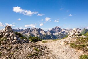 Berglandschaft mit Wanderweg unter blauem Himmel