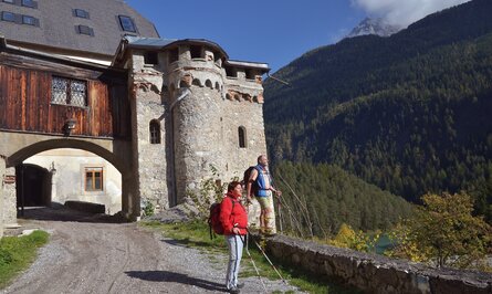 Wanderer vor Burg in Berglandschaft