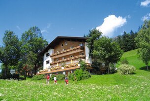 Hotel mit Balkonen auf grüner Wiese unter blauem Himmel