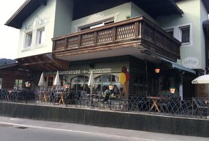 Café-Dorfstube-Restaurant mit Balkon und Tischen im Freien