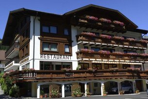 Hotel mit Restaurant und blühenden Blumenkästen an Balkonen