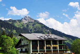 Hotel Berghof vor Berglandschaft mit blauem Himmel
