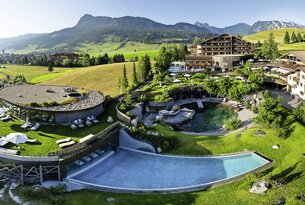 Hotelanlage mit Pool, Liegen und Bergpanorama