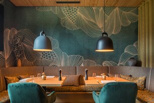 Restaurant mit Tisch, Stühlen, Lampen und Wandbild