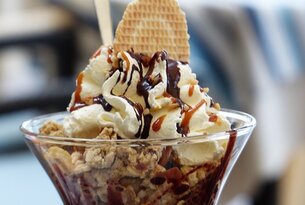Eisbecher mit Sahne, Waffel und Schokosoße im Glas