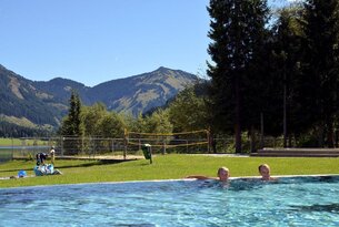 Schwimmbad mit Bergpanorama und zwei Personen im Wasser