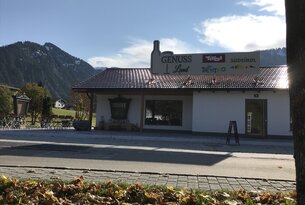 Geschäft "Genuss Landl" mit Bergen im Hintergrund