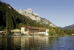 Hotel am See vor Bergkulisse