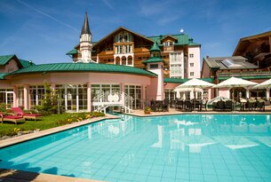 Hotel mit Pool und Terrasse an einem sonnigen Tag