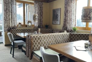 Gemütliches Restaurant mit Holztäfelung, Eckbänken und Fenstern