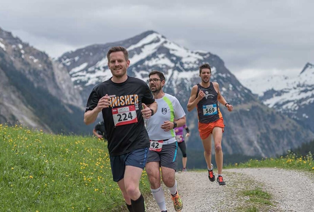 Läufer bei einem Berglauf vor Bergkulisse