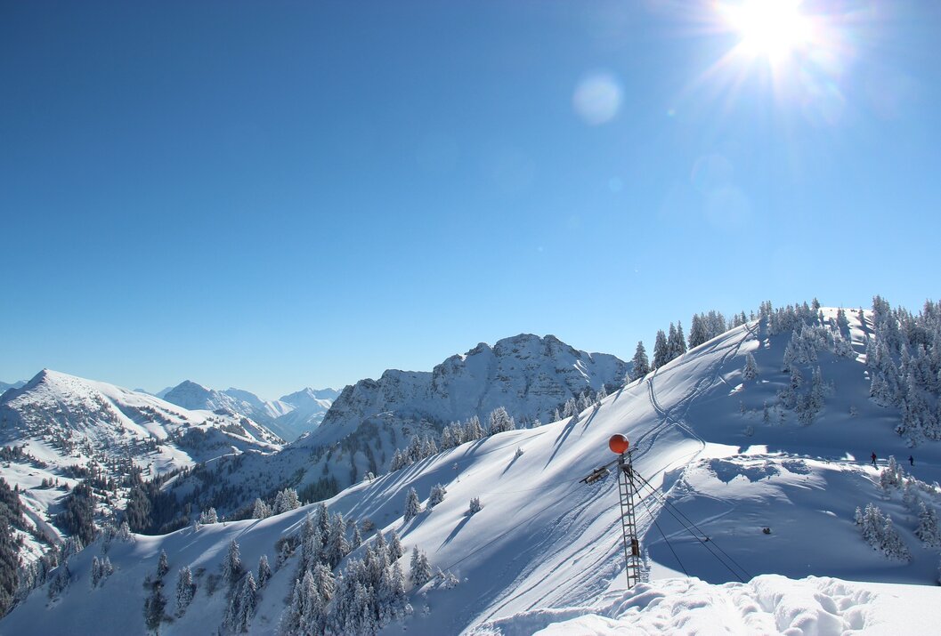 Verschneite Berglandschaft unter blauem Himmel mit Sonnenschein