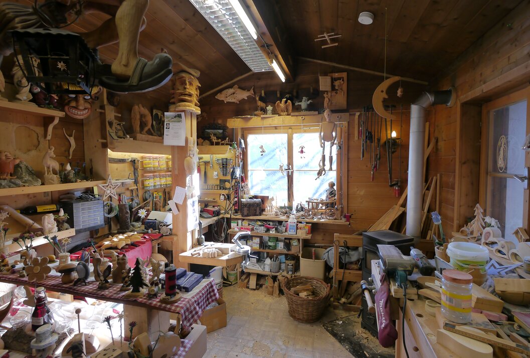 Werkstatt mit Holzwerkzeugen, Schnitzereien und einem Fenster