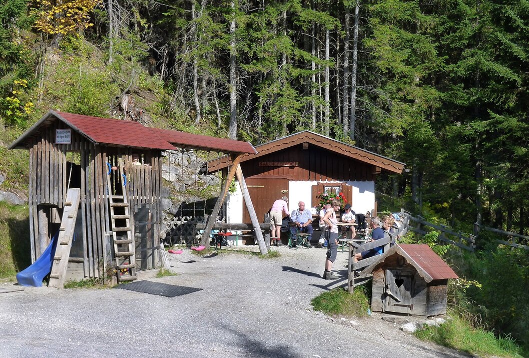 Hütte mit Gästen im Wald, Spielplatz und Leiter angebaut