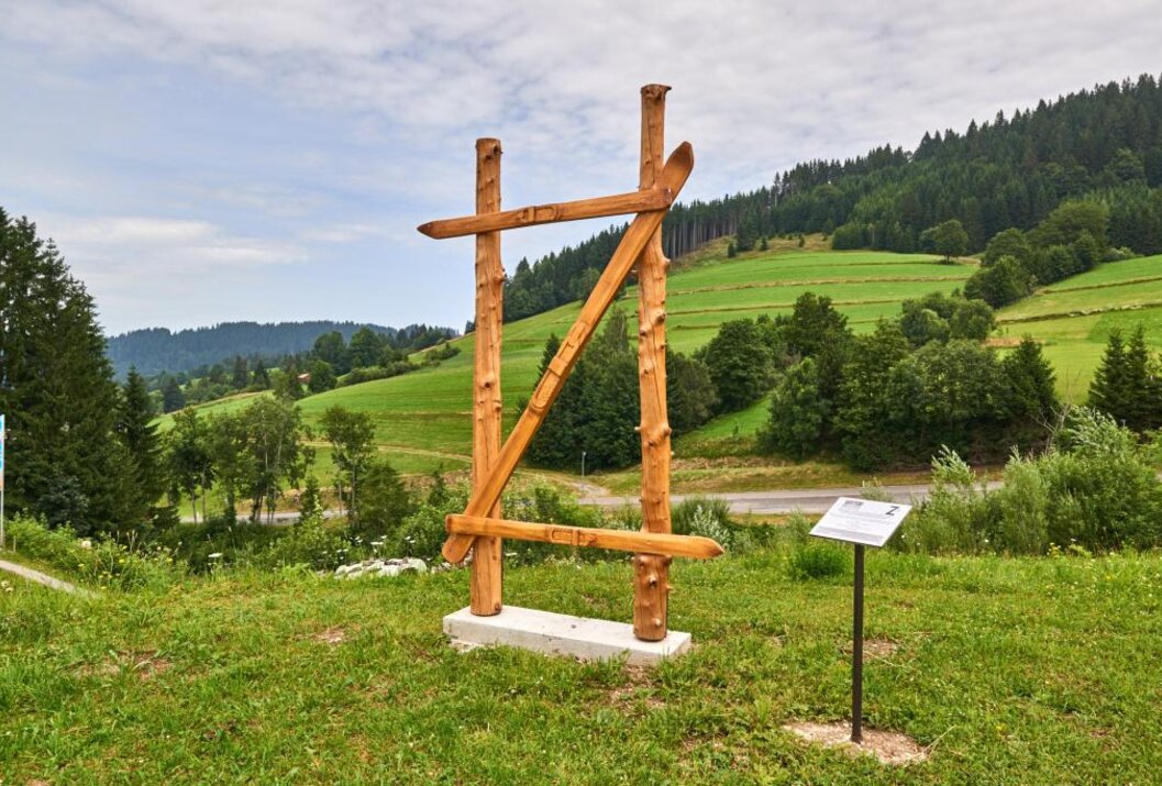 Holzkonstruktion auf Wiese vor hügeliger Landschaft