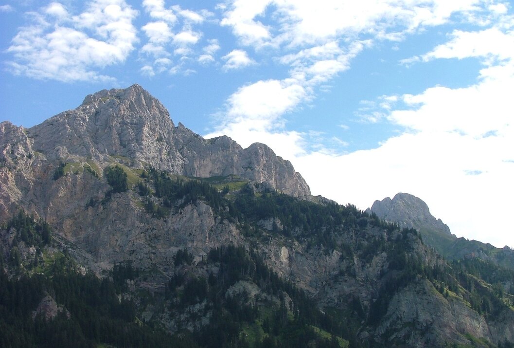Mountain landscape with rocks, trees and blue sky with clouds