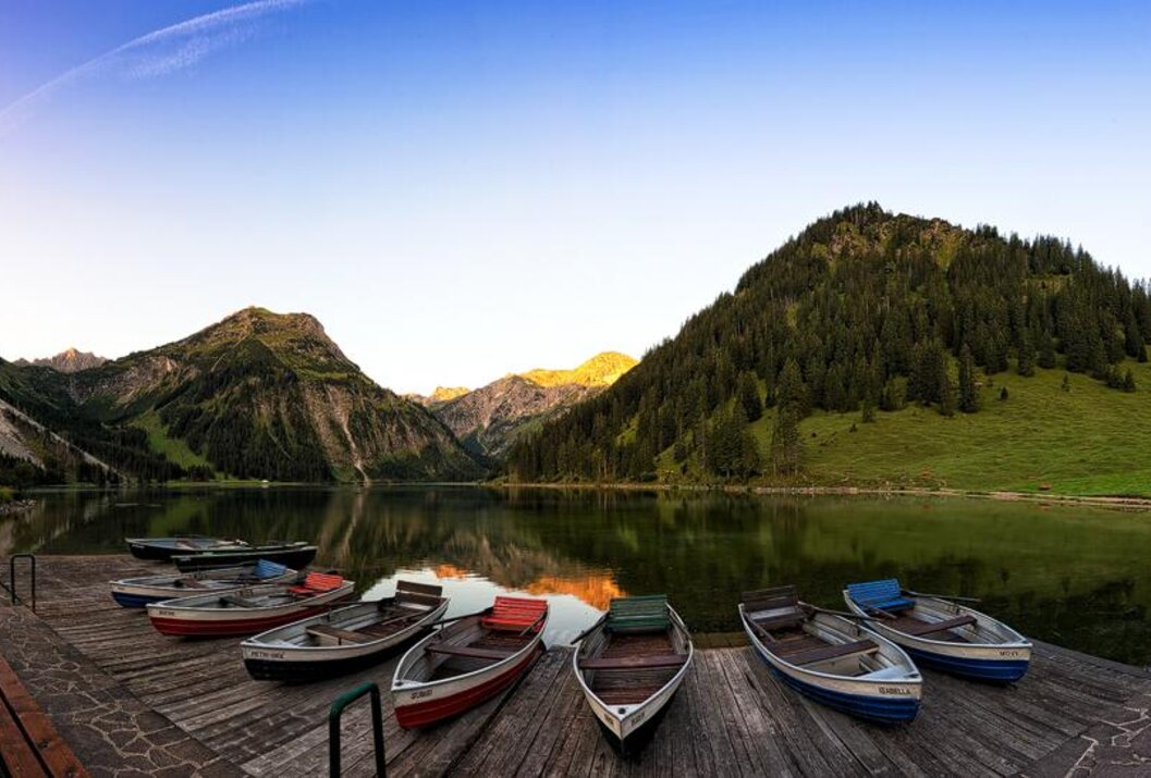 Boote an einem See mit Bergen im Hintergrund