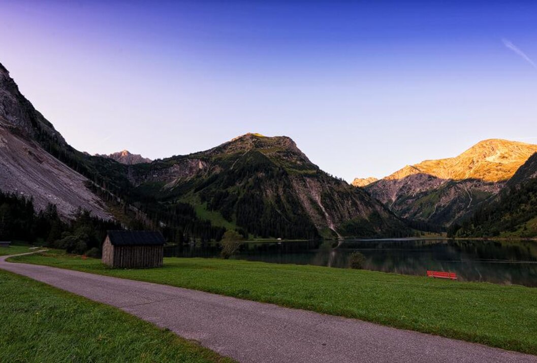 Berglandschaft mit See, Hütte und Weg im Abendlicht