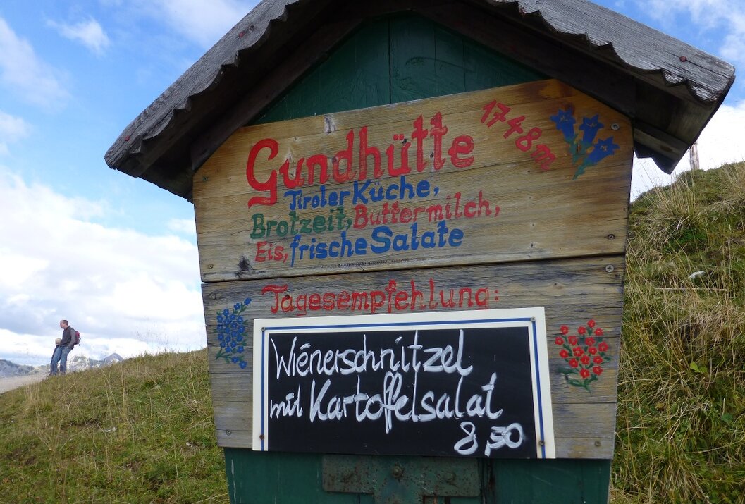 Holzhütte mit Speisekarte: Gundhütte, Tiroler Küche, Wiener Schnitzel mit Kartoffelsalat