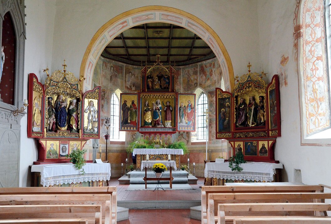 Innenansicht einer Kirche mit Altar und Flügelaltären