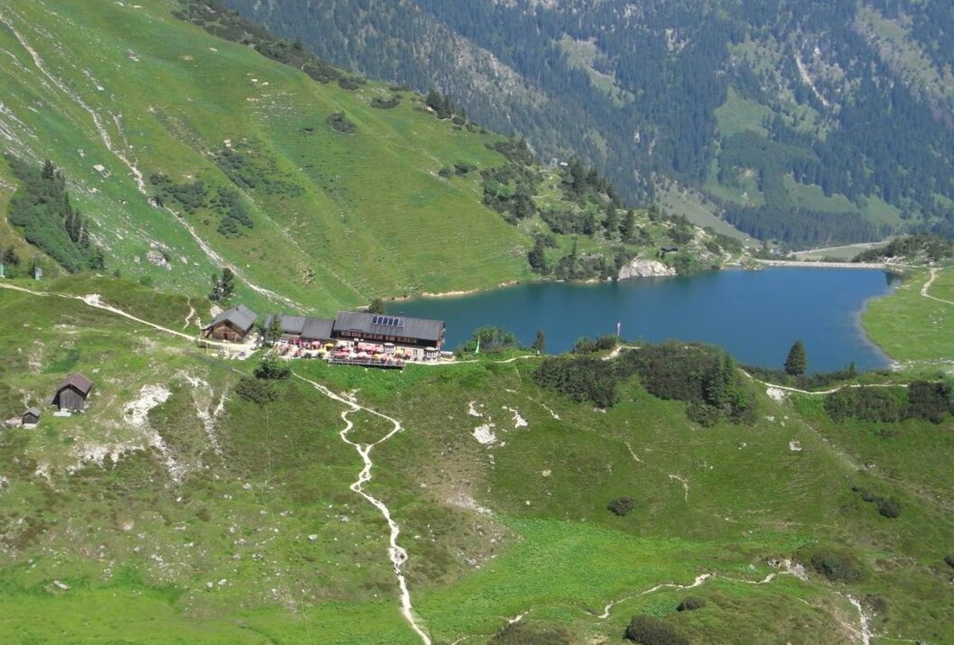 Berglandschaft mit Hütte am See und Wanderweg