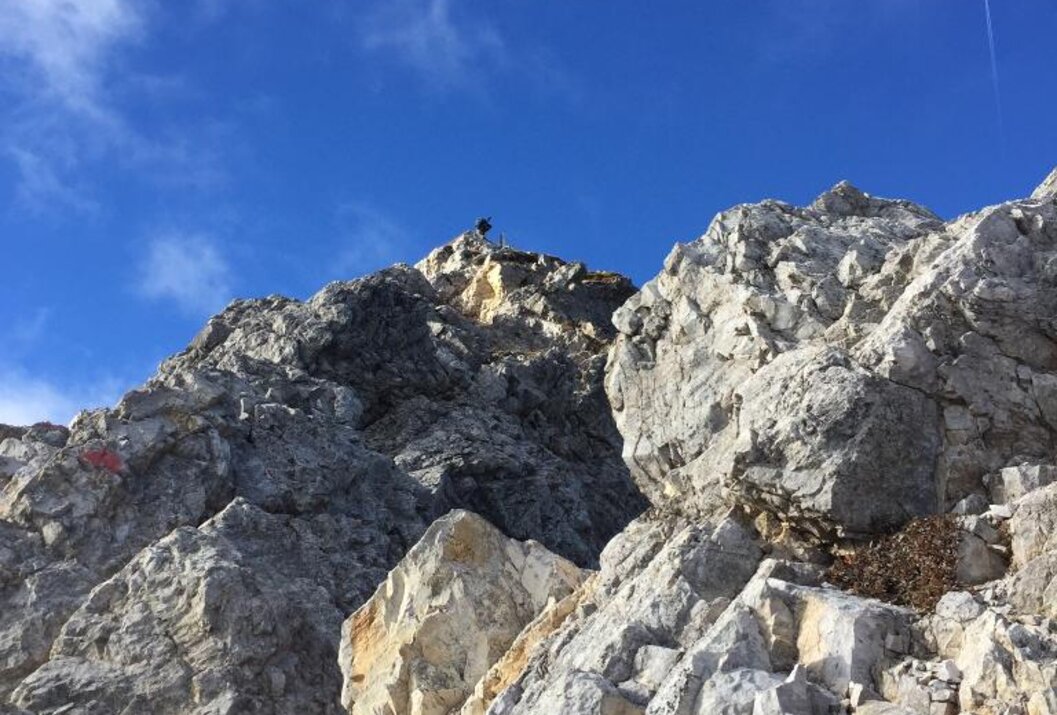 Felsiger Berggipfel unter blauem Himmel mit vereinzelten Wolken
