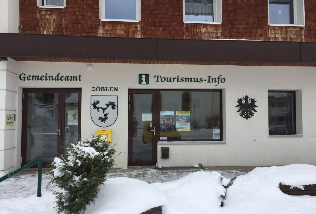Gebäude mit Tourismus-Info Zöblen im Winter mit Schnee vor der Tür