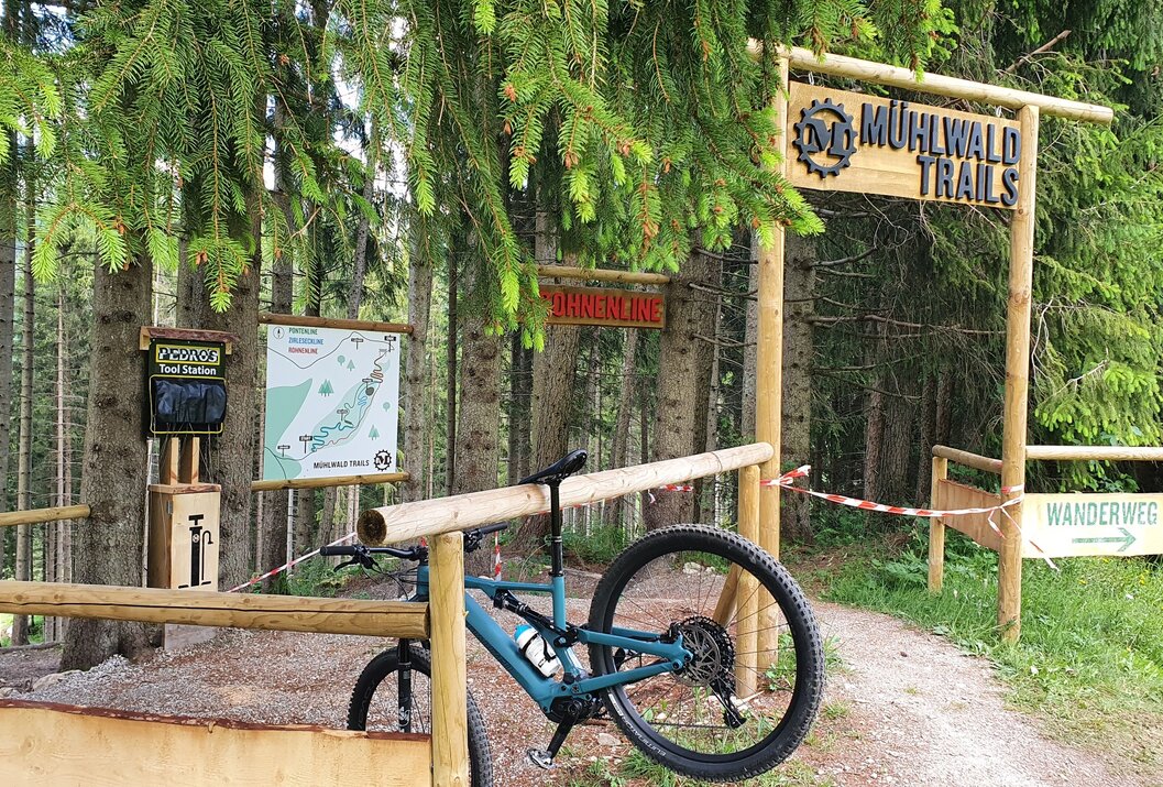 Mountainbike vor Mühlwald Trail-Schild im Wald