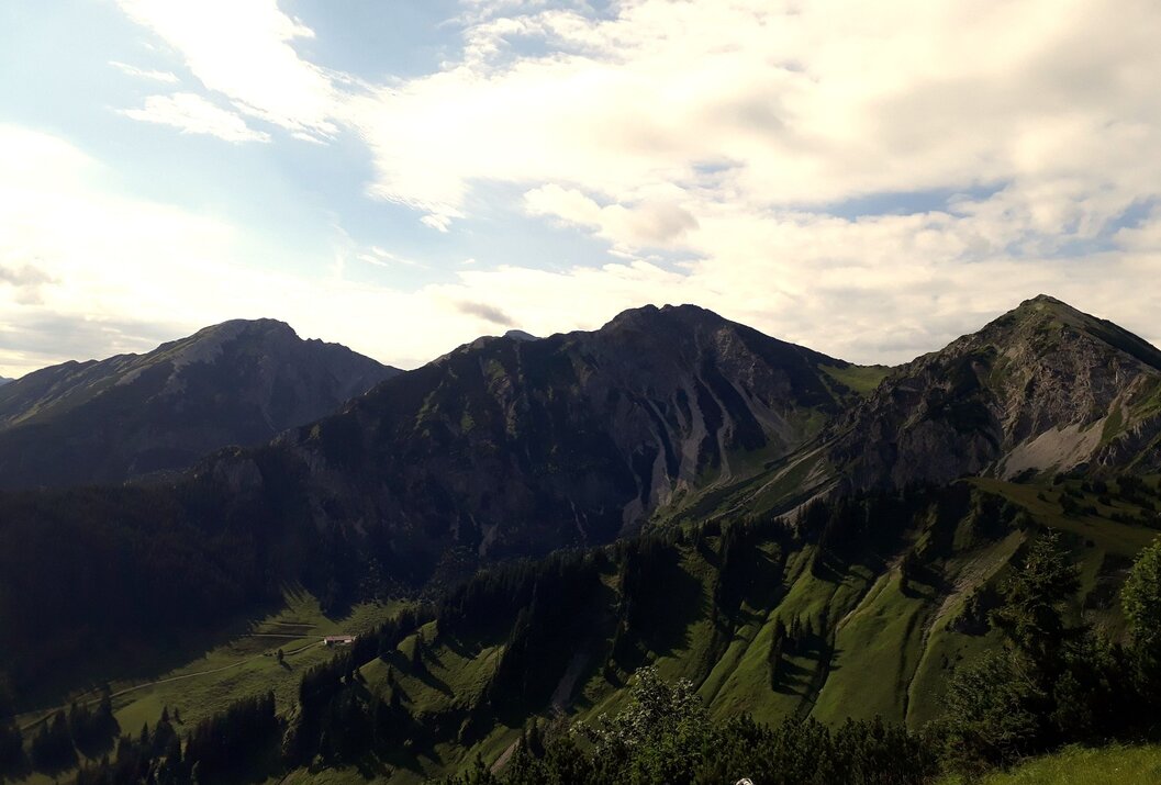 Berglandschaft mit grünen Hängen und bewölktem Himmel