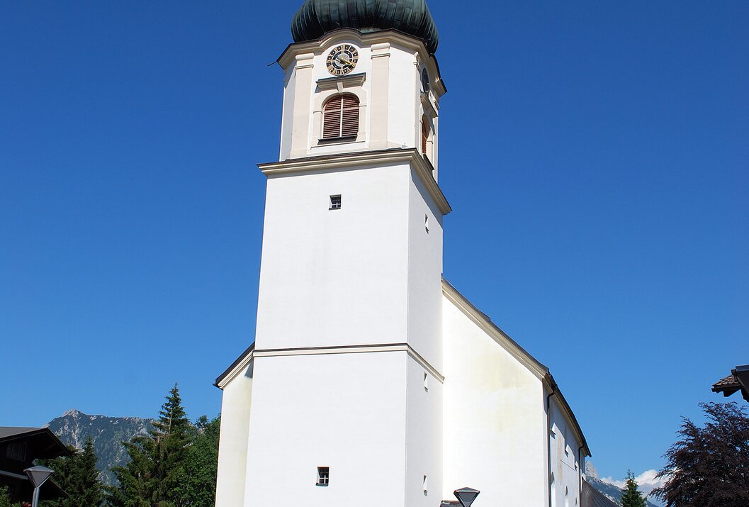 Weiße Kirche mit Turm unter blauem Himmel