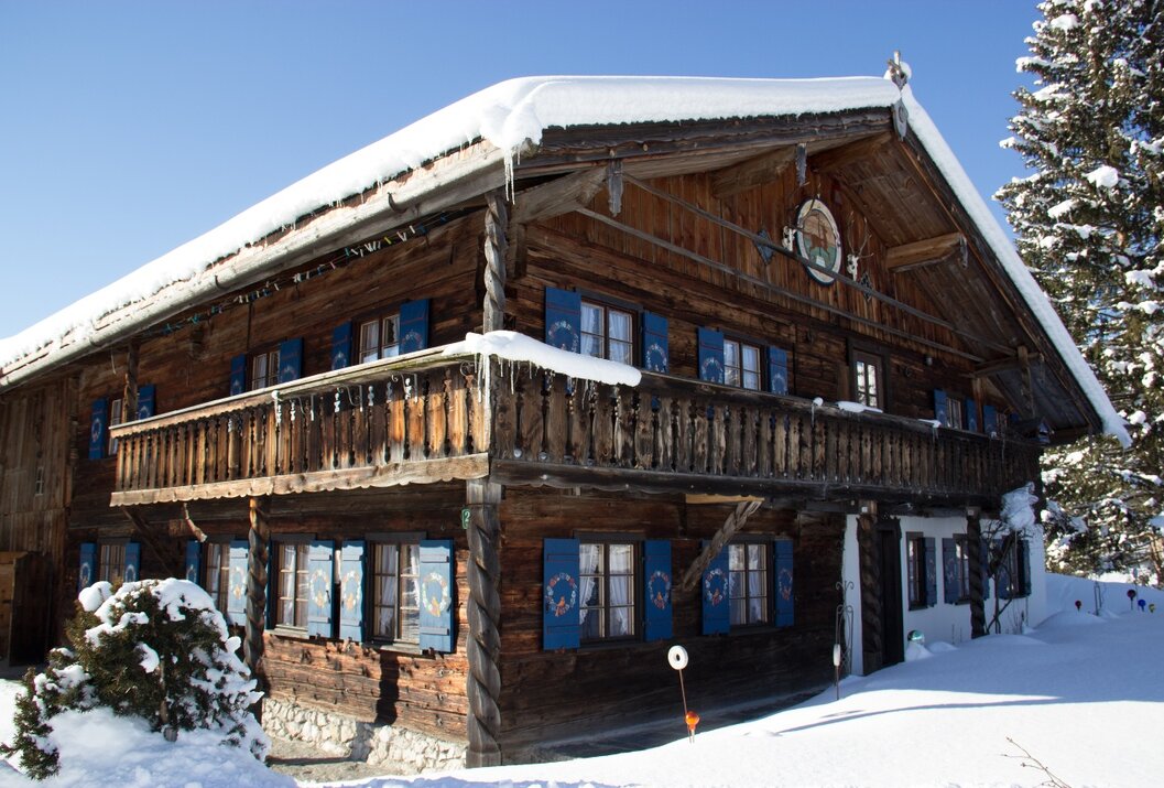 Holzhaus mit blauen Fensterläden im Schnee