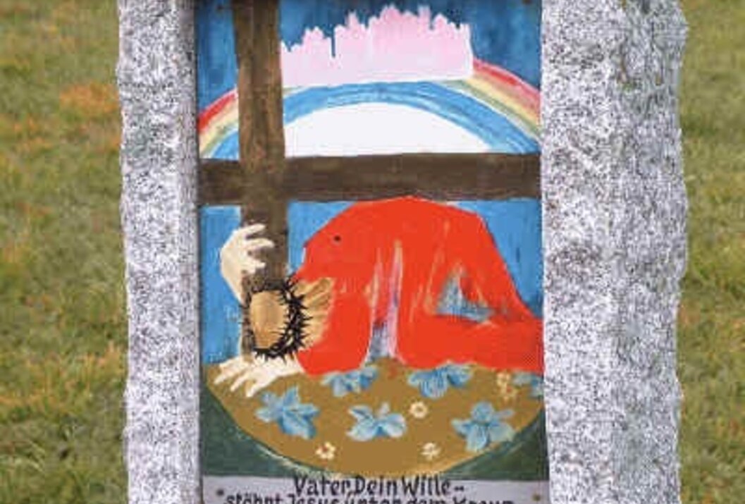 Religiöses Bild in Steineinfassung: Jesus unter Kreuz, Regenbogen, Inschrift "Vater Dein Wille"