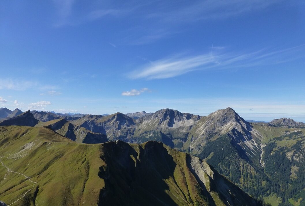 Berglandschaft unter blauem Himmel mit vereinzelten Wolken