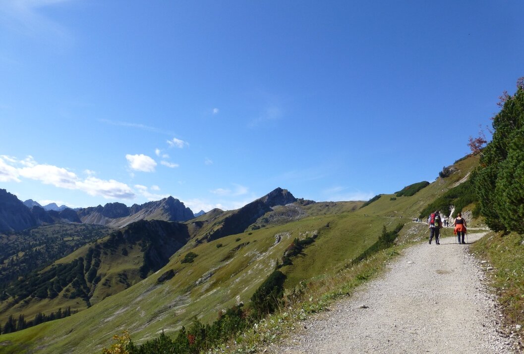 Berglandschaft mit Wanderweg unter blauem Himmel