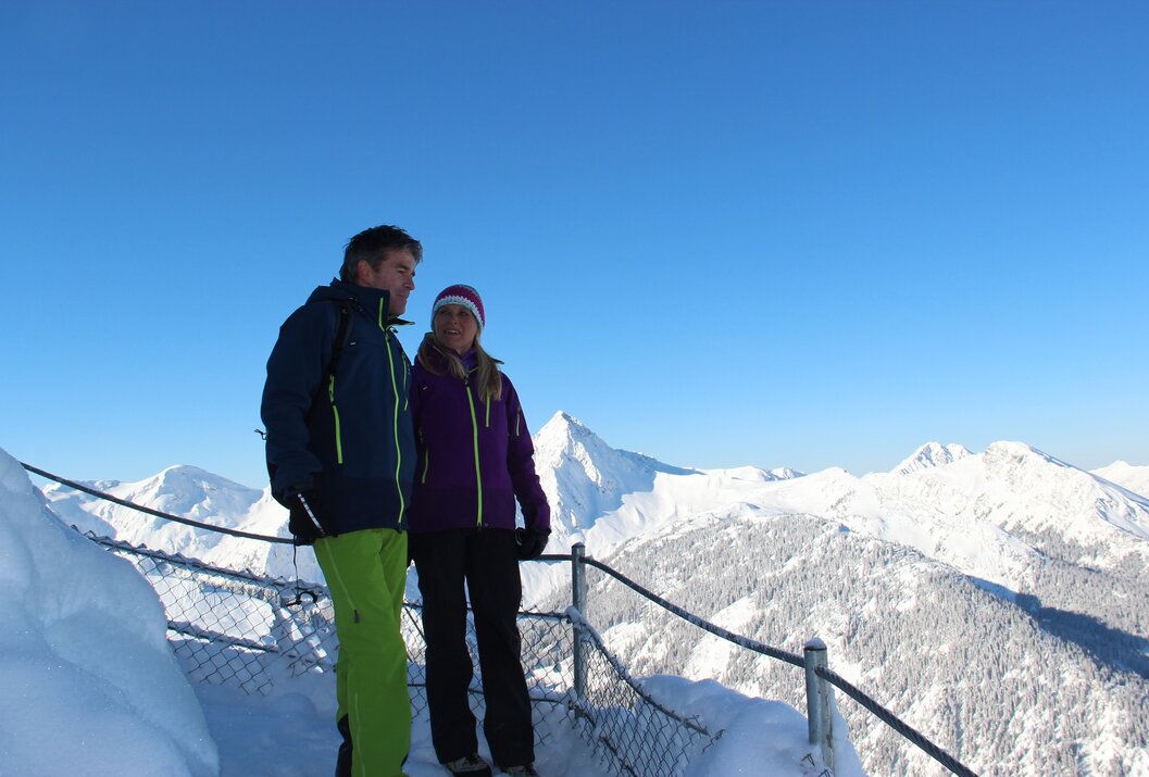 Paar auf schneebedecktem Berg mit Blick auf Bergpanorama