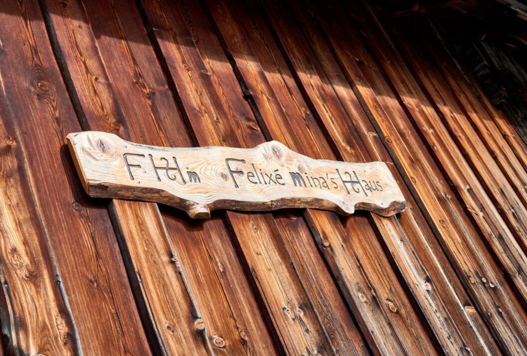 Holzschild "Flim Felixé Mina's Haus" an brauner Holzwand