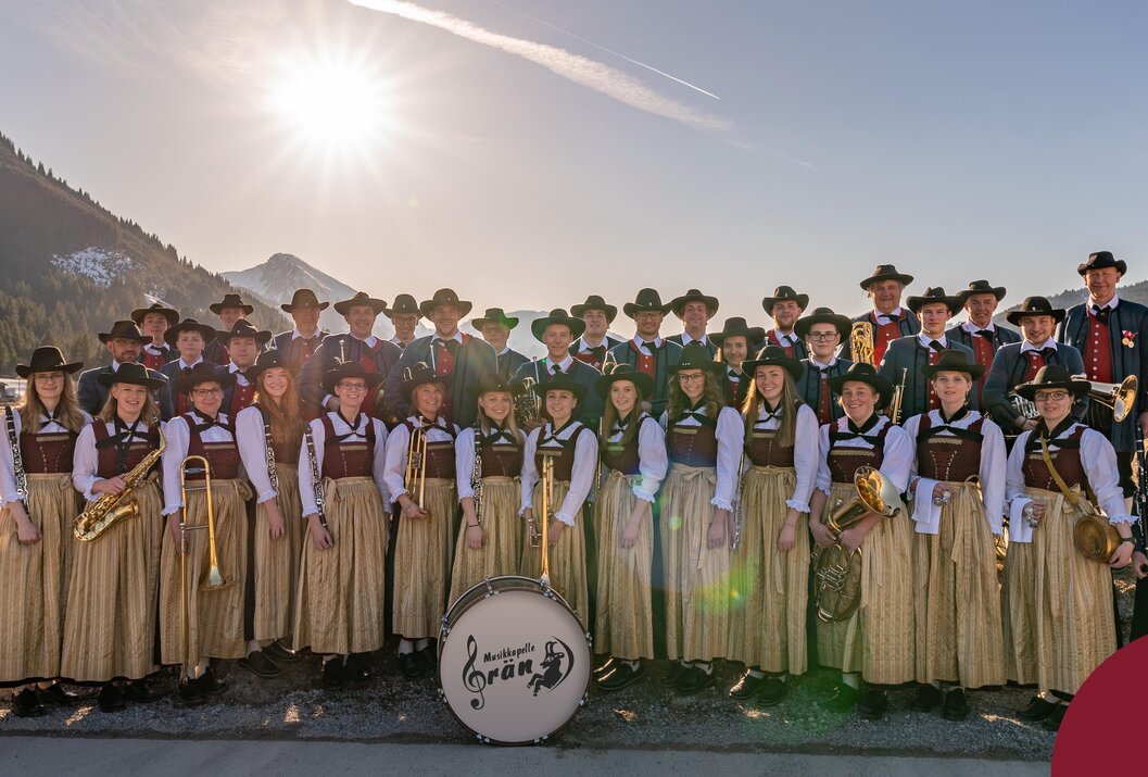 Trachtenkapelle mit Instrumenten vor Bergkulisse