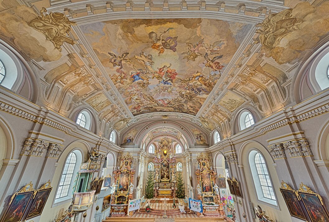 Innenansicht einer Kirche mit Deckenfresko und Altarraum