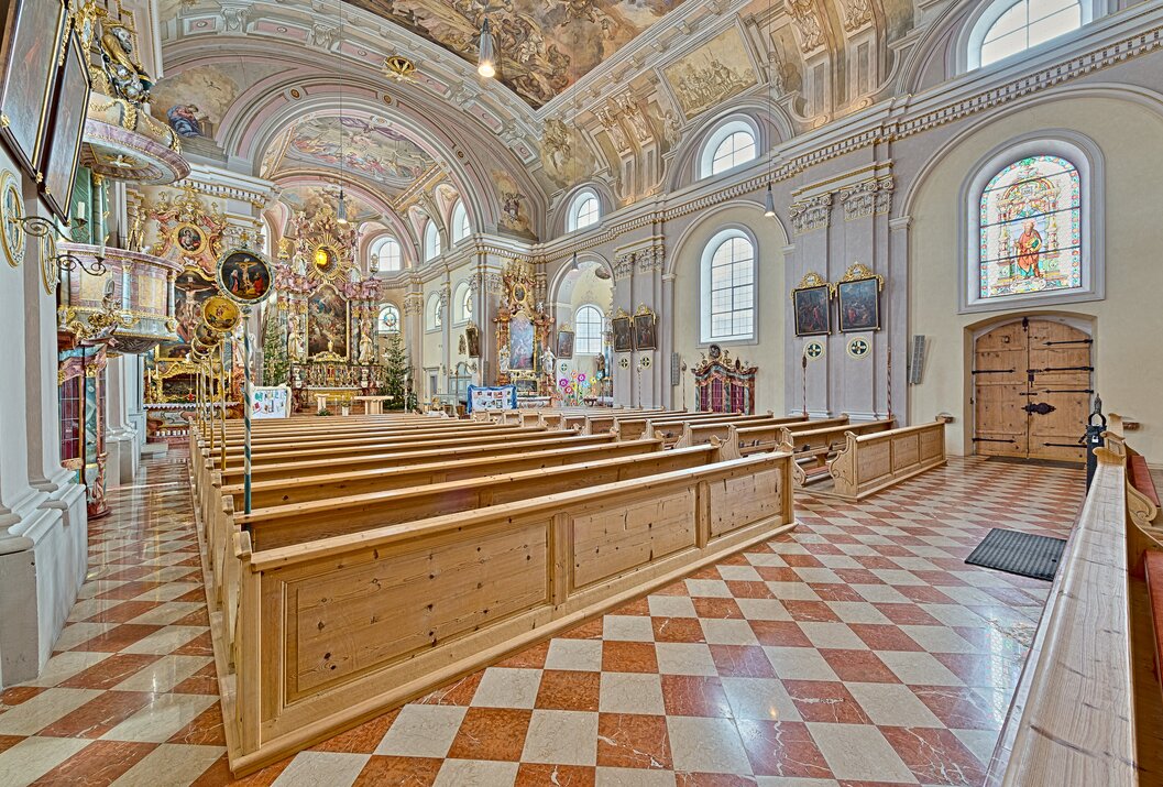 Innenansicht einer Kirche mit Bänken, Altar und Deckenmalerei